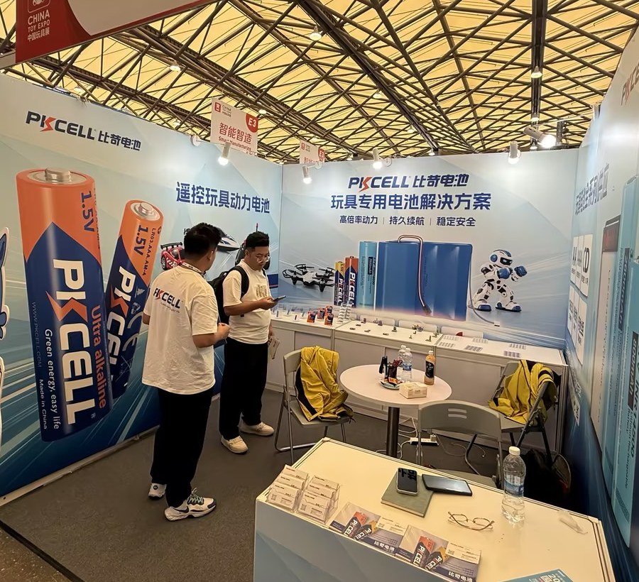 PKCELL中国玩具展展位内工作人员与来访者查看产品并沟通电池需求。