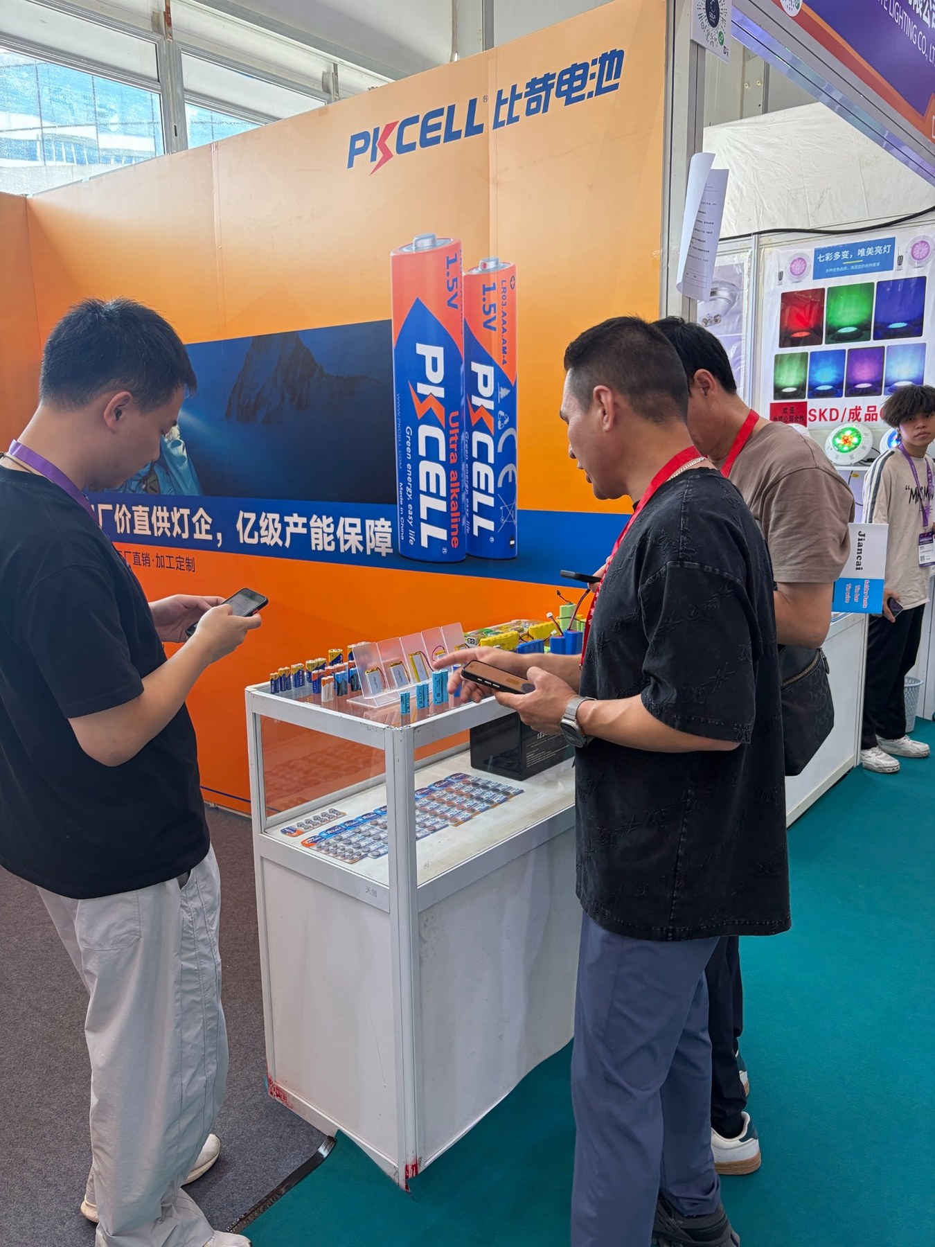 PKCELL工作人员与来访者在古镇灯博会展位围绕电池样品进行交流