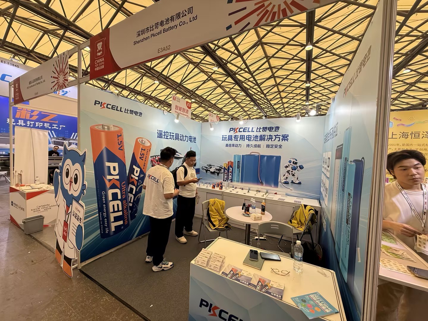 第24届中国玩具展PKCELL展位侧面视角，工作人员在展台内介绍电池样品。
